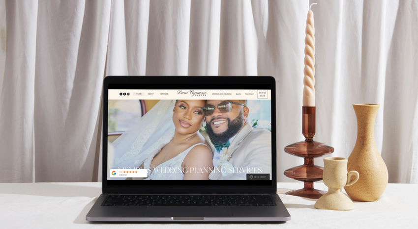 Dani Cymone Events, a wedding and event planner website on a laptop mockup sitting on a counter with a candle and vases