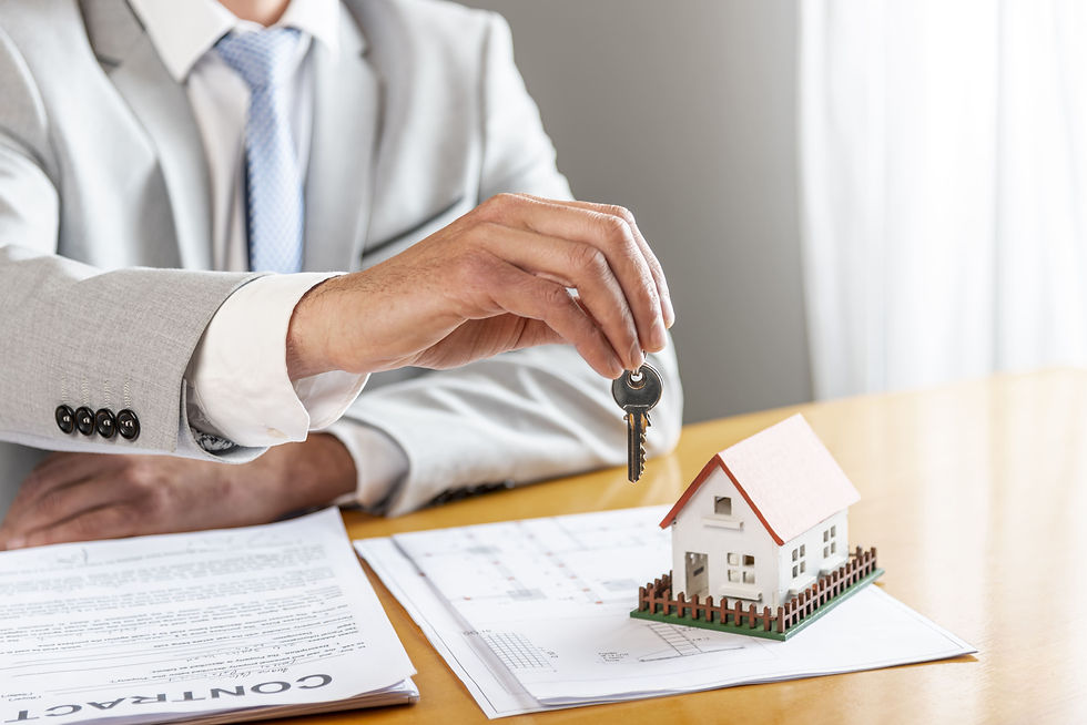 person-holding-house-keys-toy-model-house-desk.jpg