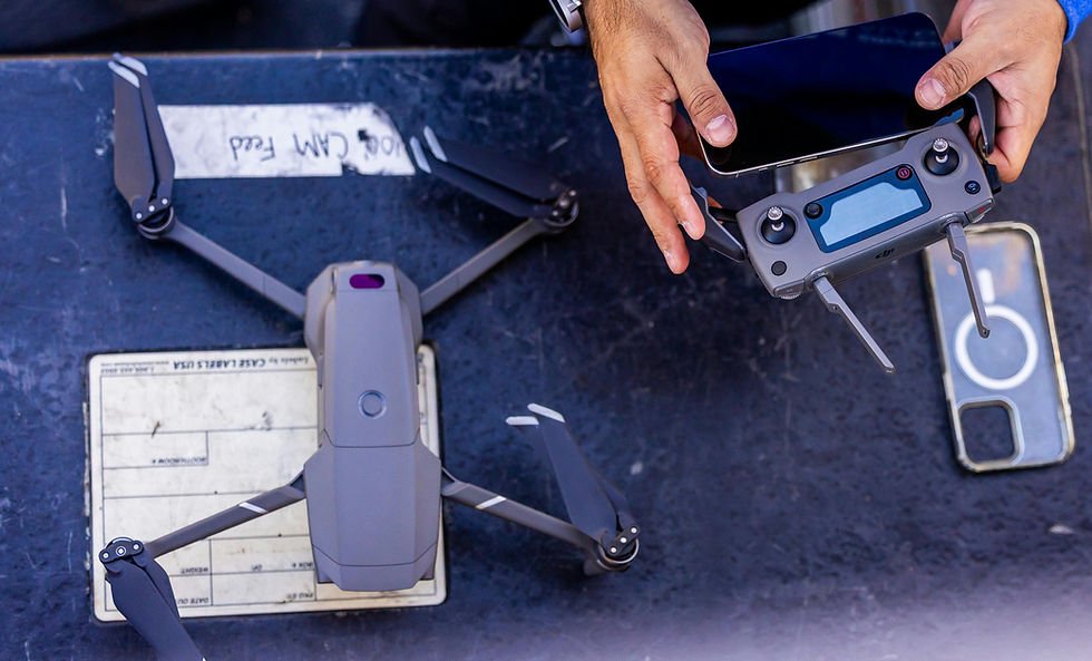 Drone and remote with phone. Hands holding the remote, ready to fly.