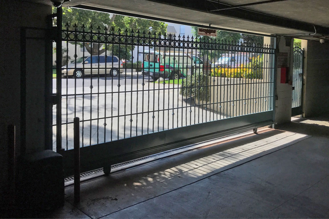 Black iron security gate at a covered parking garage entrance in Canoga Park, CA