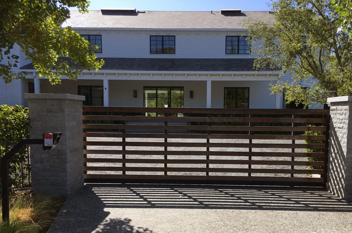 Horizontal wood-slat slide gate with steel frame in front of a modern farmhouse-style home in Chatsworth, CA