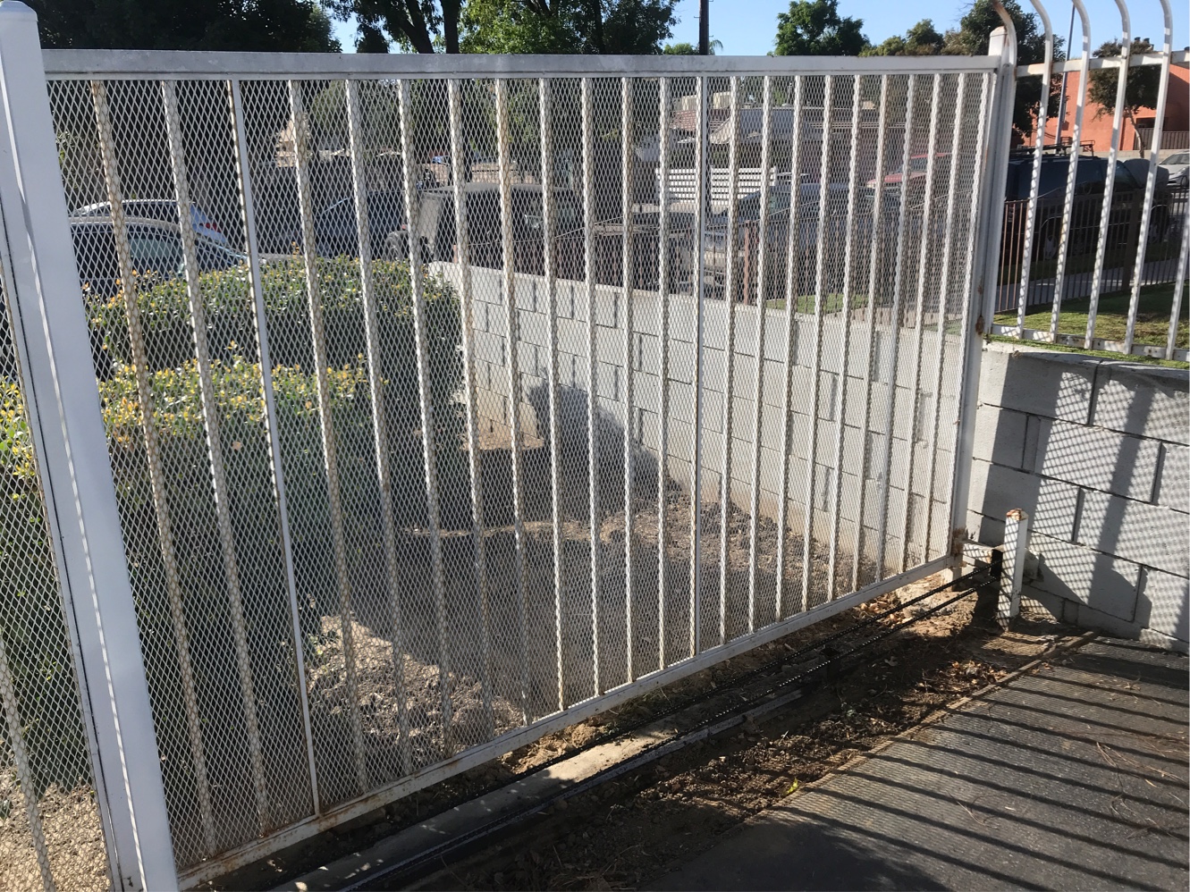 White steel slide gate with gate operator across a residential driveway in Van Nuys, CA