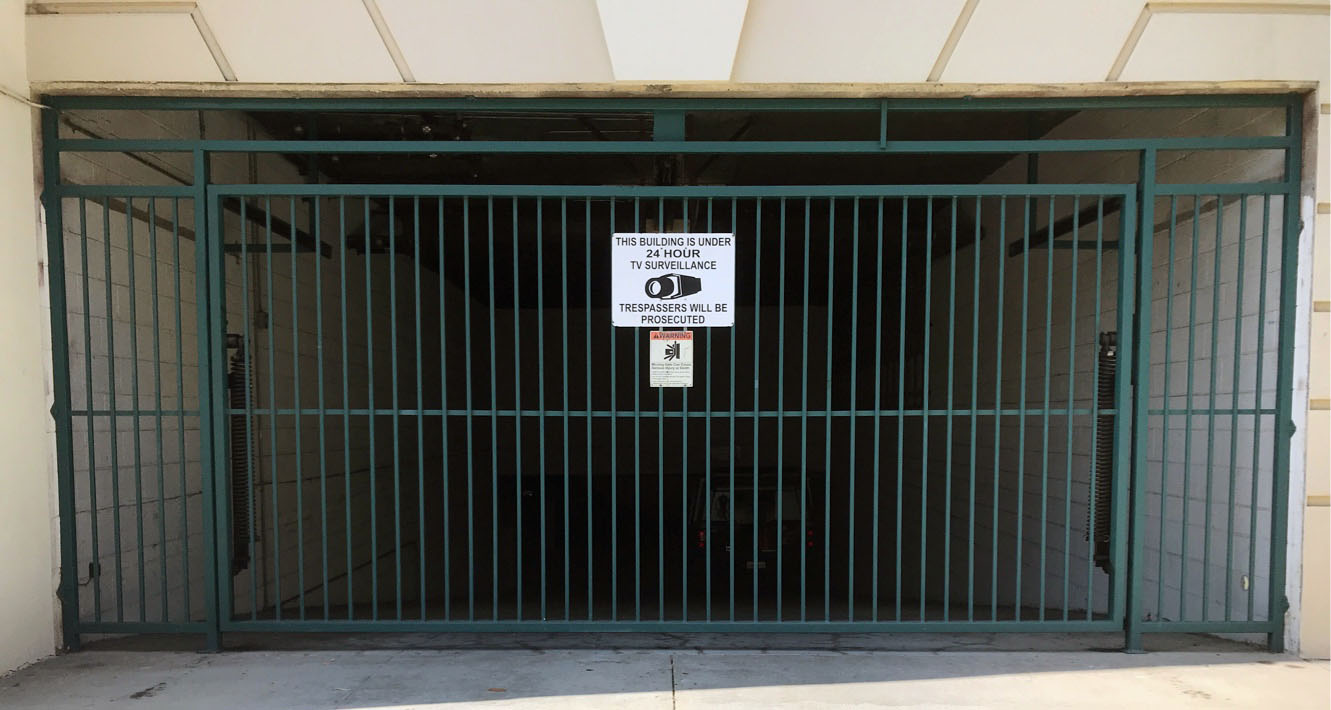 Green steel garage security gate at an apartment building parking entrance in Reseda, CA