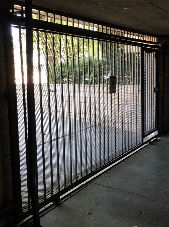 Black iron garage security gate at a covered parking entrance in San Fernando, CA