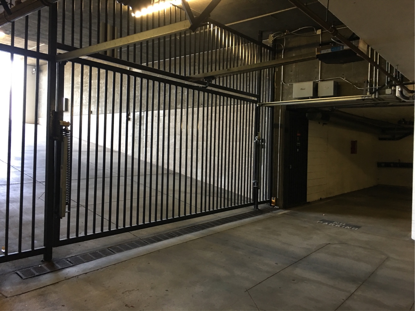 Black iron garage security gate inside a covered parking structure in Winnetka, CA