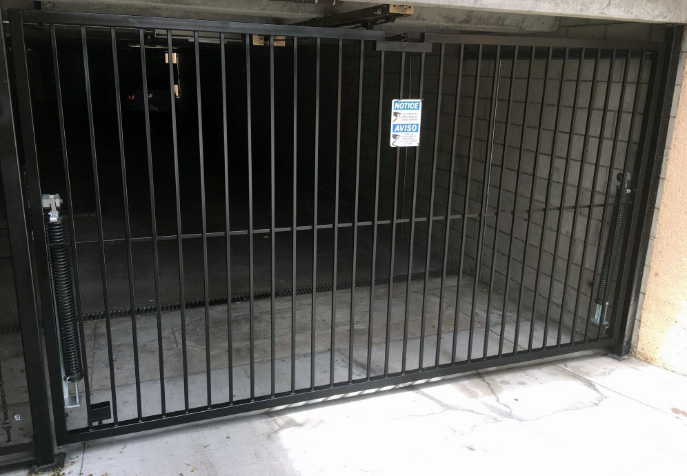 Black iron garage security gate at an apartment building parking entrance in Winnetka, CA