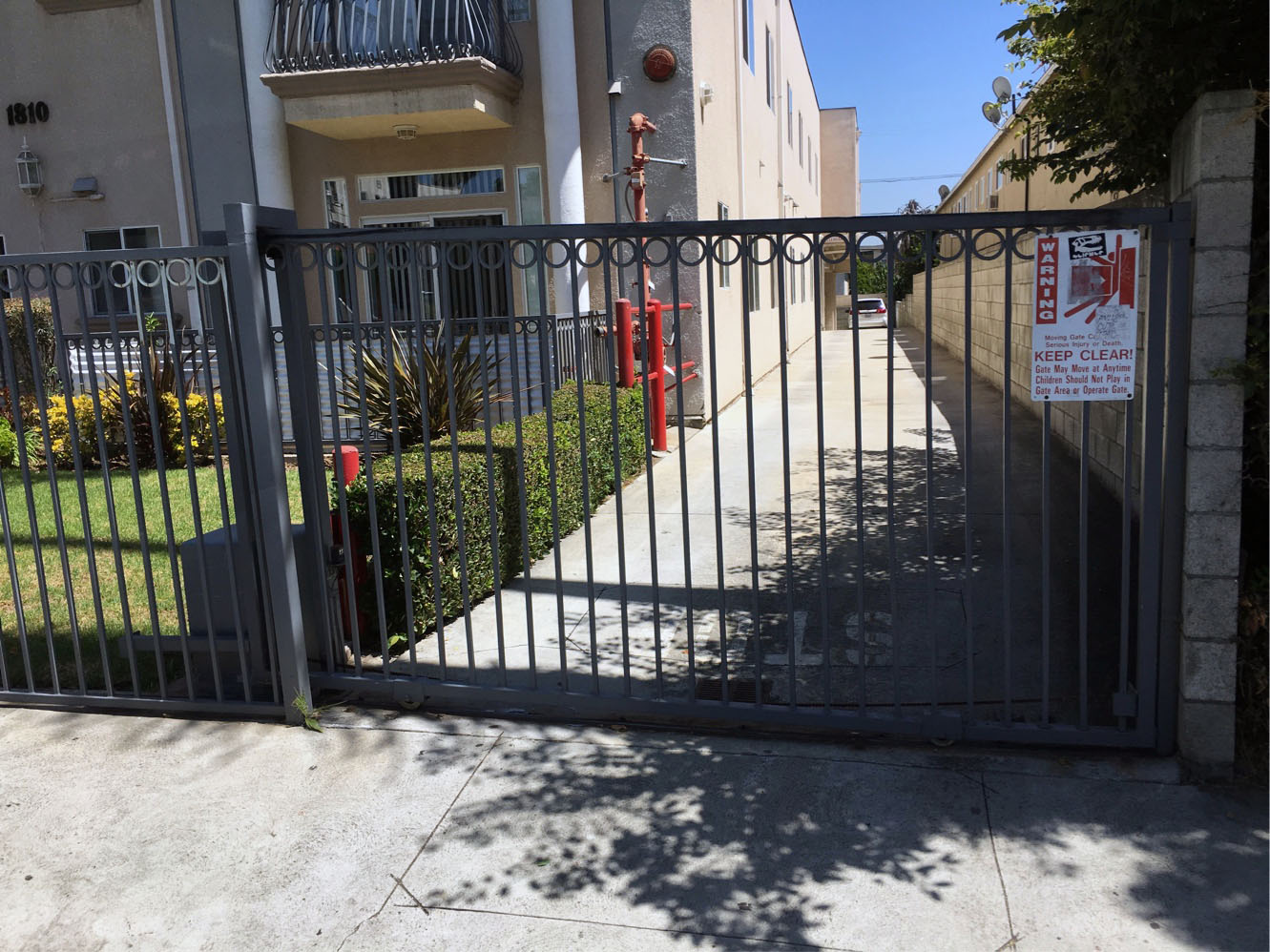 Black iron slide gate at an apartment building driveway entrance in Northridge, CA