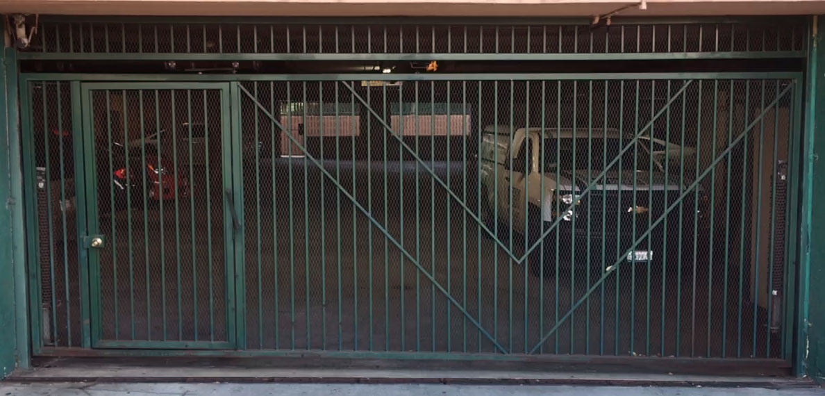 Green steel garage security gate at an apartment building parking entrance in Arleta, CA