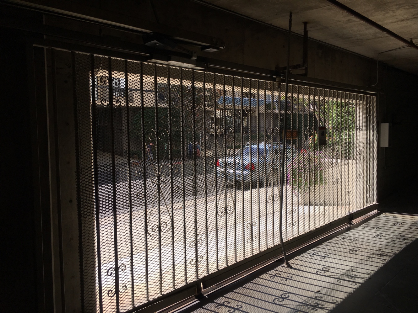 Black iron garage security gate at a covered parking entrance in Reseda, CA