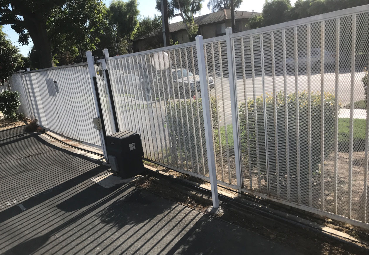 White steel slide gate and fence with gate operator at a residential property in North Hills, CA