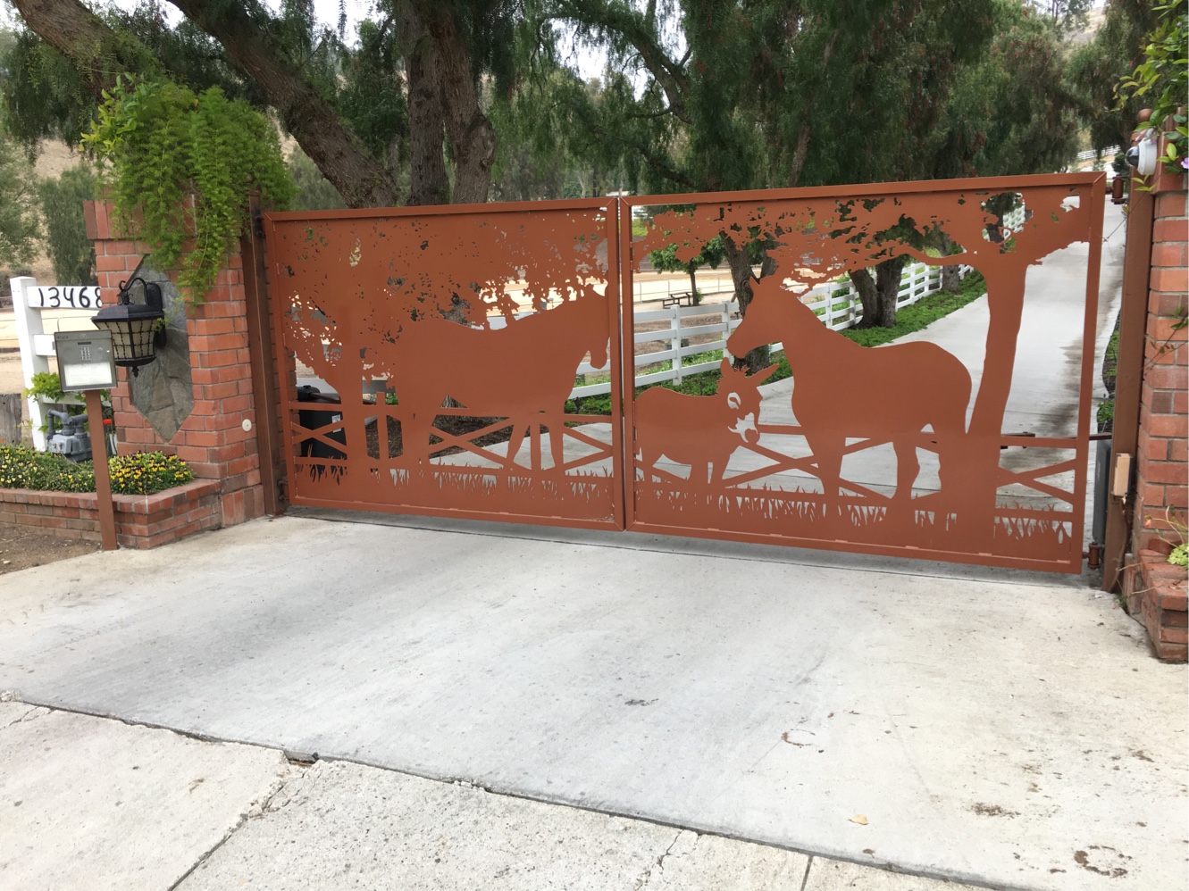 Rust-finish steel driveway gate with laser-cut horse silhouettes in Moorpark, CA