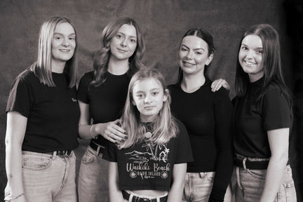 South Wales family photographer capturing five sisters in a classic black‑and‑white studio portrait. A relaxed, connected group pose that reflects natural family photography, sibling relationships, and expressive, cinematic storytelling.