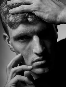 Schwarz-weiß-Porträt eines jungen Mannes mit Händen