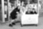 female dry cleaning staff members playfully in linen container