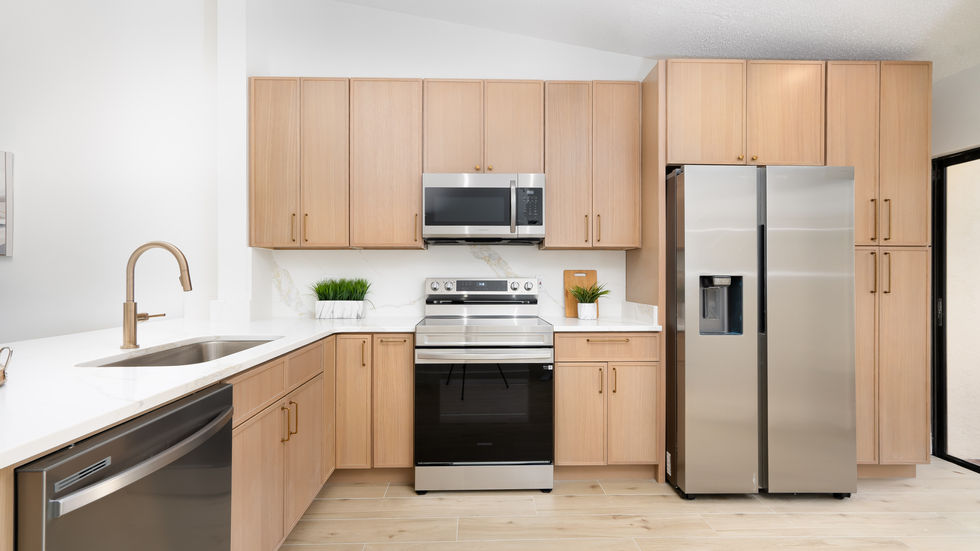 Modern kitchen with stainless steel appliances and wooden cabinets.
