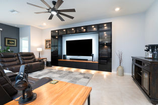 Modern living room with large TV and sleek decor.