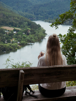 Frau die auf einer Bank sitzt und auf den Edersee blickt