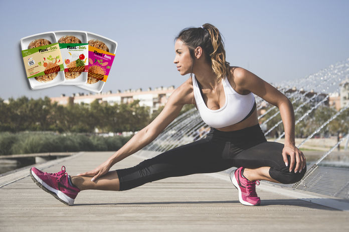 Jeune femme urbaine en tenue de sport en train de faire des étirements dehors sur un ponton en bois près d'une fontaine au soleil. Trois barquettes de haché viande de boeuf origine France et légumes Flexi-bon affichée en éventail dans le coin gauche.