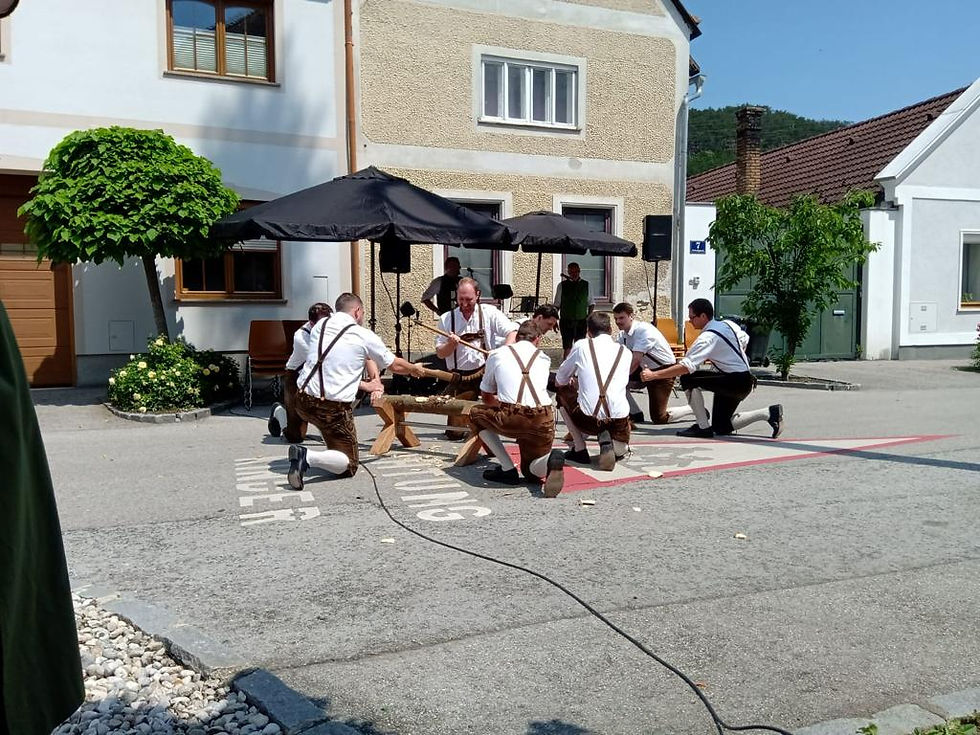 Männer verwenden traditionelle Werkzeuge, um Holz auf einer Veranstaltung zu bearbeiten.