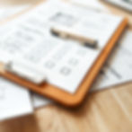 Close up on a clipboard for construction inspection. Paperwork on clipboard is out of focu