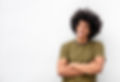 Portrait of cool young handsome man with afro hair smiling with arms crossed by white back