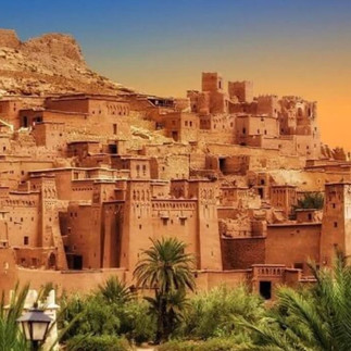 Ancient kasbah and Berber village in southern Morocco, made of mud-brick architecture and surrounded by palm trees.