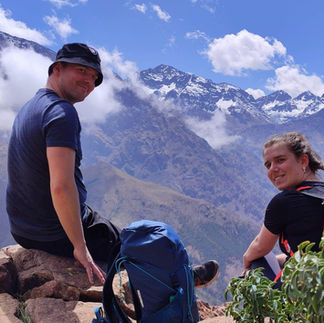 Couple sitting on a rock near the summit of Adrar Talamrout during a day hike from Marrakesh in the Atlas Mountains