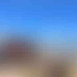 Group of hikers celebrating at the summit of Adrar Talamrout after a successful day hike from Marrakesh in the Atlas Mountains