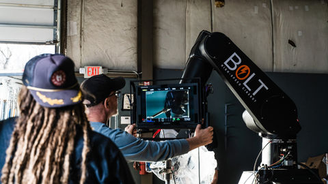 Man operating Bolt robotic arm, monitoring underwater feed