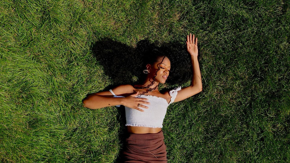Beautiful goddess lays atop a lush green field