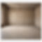 Professional image of an empty room with brown cement floor and beige cinderblock walls.jp