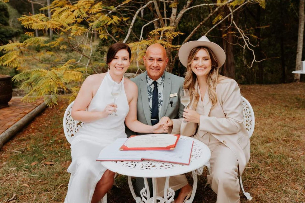 Couple signing their marriage documents with celebrant Johnnathan Day during an intimate outdoor wedding