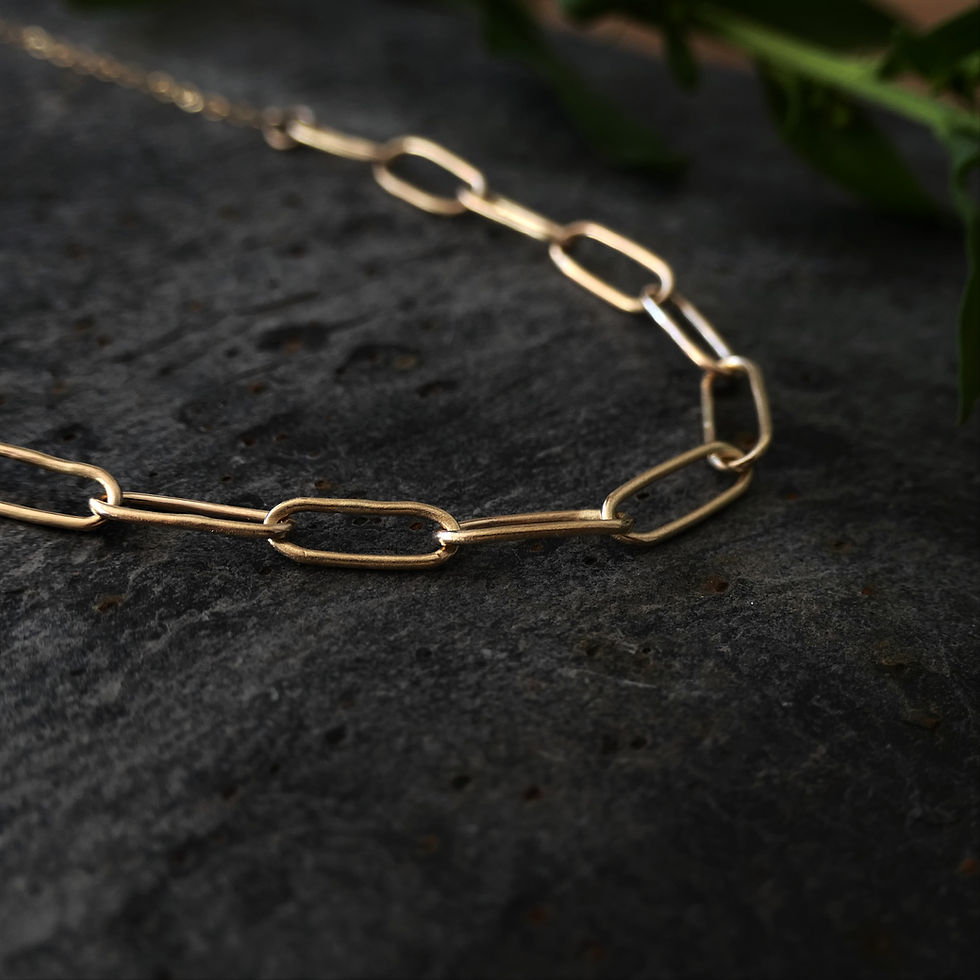 Close up view of a few links of the paperclip chain in gold
