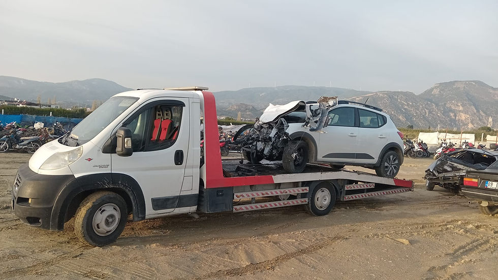 Hasarlı beyaz aracı taşıyan kurtarıcı çekici