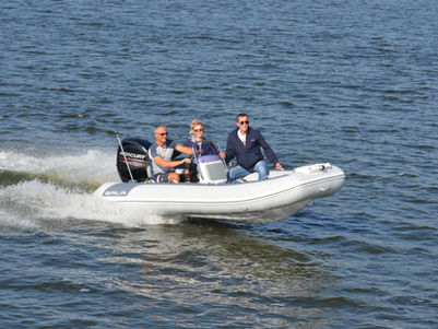 Three men riding in a white speed boat
