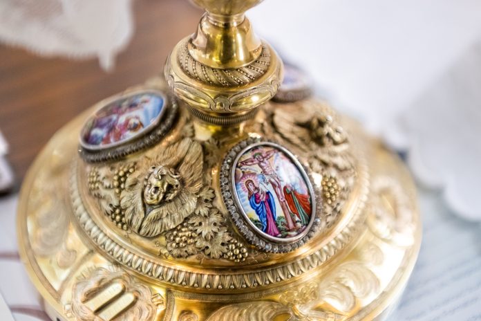 A chalice bearing an image of the cruxifixction of Jesus Christ sits during Mass. (Photo by Daniel Petty/Denver Catholic)