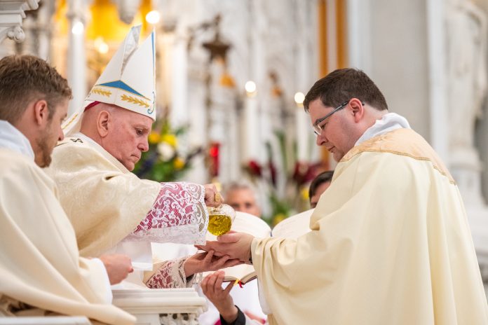 Archbishop Samuel Aquila anoints the hands of Fr. Kevin Kasel with sacred chrism during his priestly ordination. These very hands will elevate the Eucharist at Mass, anoint the sick and dying and give blessing to the faithful. (Photo by Daniel Petty/Denver Catholic)