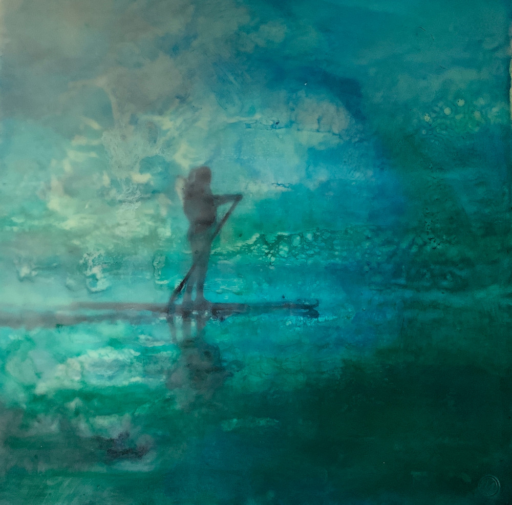 An encaustic image of a young woman on the sea on a stand up paddle board