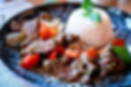 Beef stir-fry with red peppers and basil, served with a mound of white rice on a dark plate, warm and appetizing.