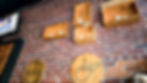Brick wall with wooden boxes holding candles. Round wooden signs read George Remus and Jim Beam. TV screen shows a person. Cozy ambiance.