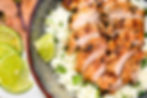 Grilled chicken slices on cilantro lime rice in a rustic bowl, garnished with lime wedges. Fresh, vibrant, and appetizing.