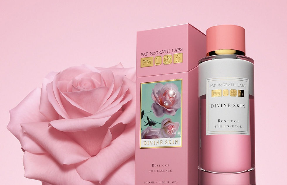 Pink bottle and box of "Divine Skin" by Pat McGrath Labs with rose design against a pink background. A large pink rose is featured.