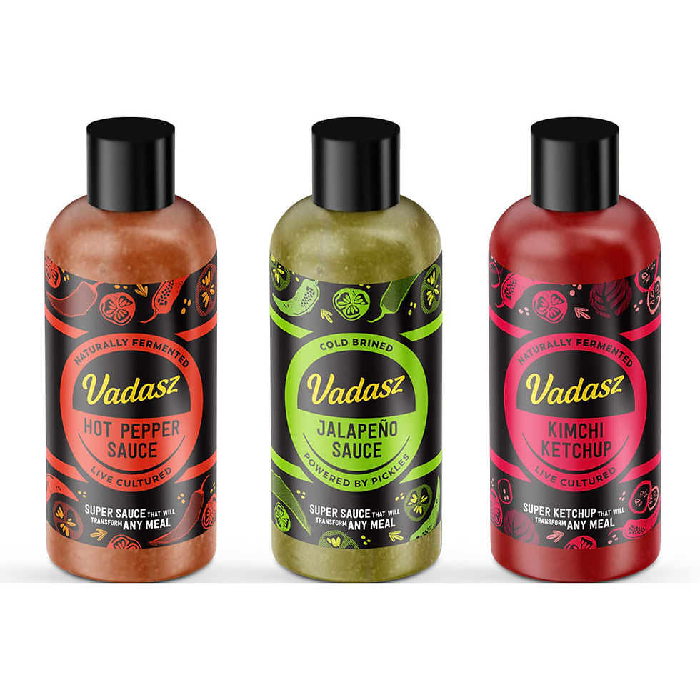 Three bottles of Vadasz sauce: Hot Pepper, Jalapeño, and Kimchi Ketchup. Each has vibrant colored labels with decorative patterns.