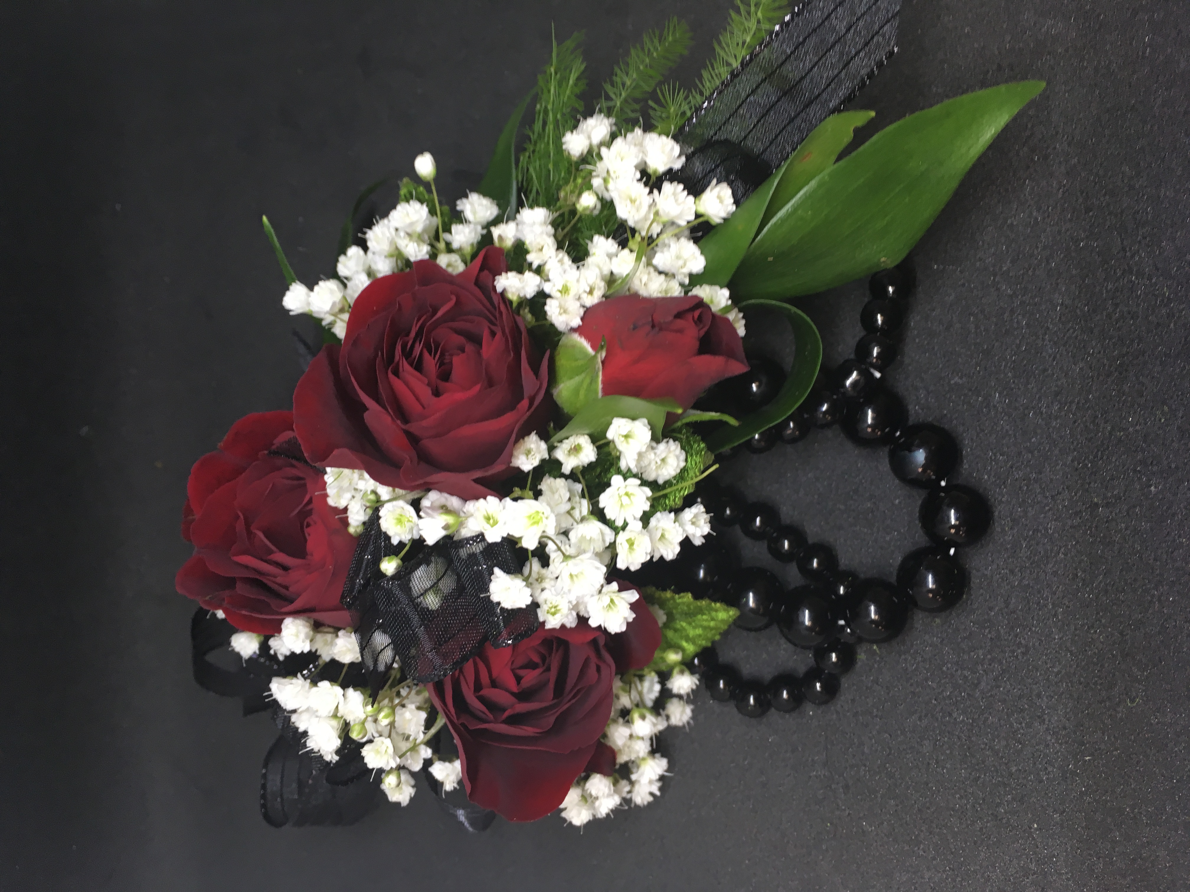Red spray rose corsage with black