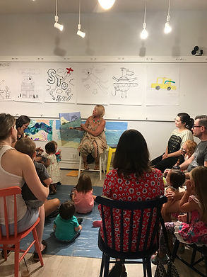 Jackie reading book to a class of students.