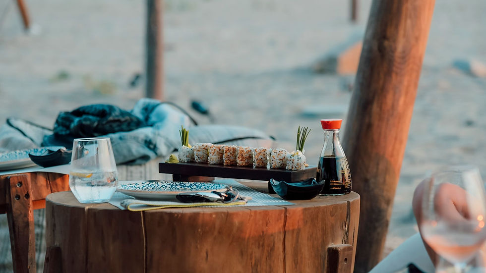 Cozy outdoor setting with sushi and drinks on a rustic wooden table. Perfect for casual dining.