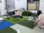 Person testing artificial turf samples in a lab setting.