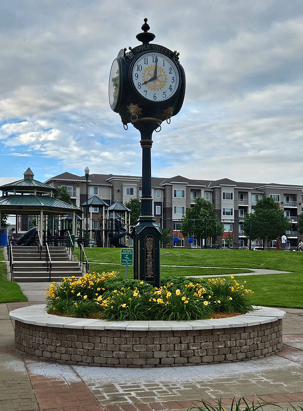 Image of the clock tower located in Apple Valley's Kelley Park. The park's playground is in the background.