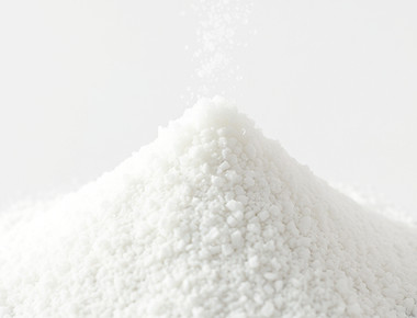 pouring crystalline powder, like salt, into a small pyramid pile of crystalline powder sma