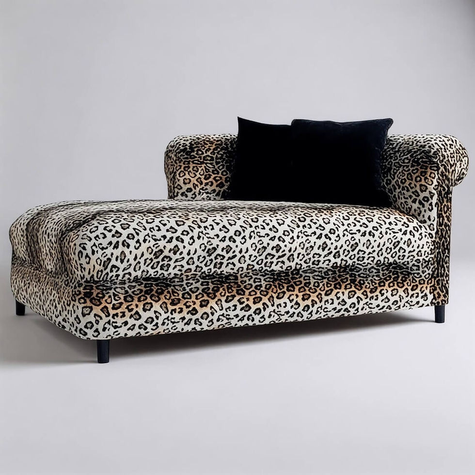 Leopard print chaise lounge with a rolled back and arms, featuring a single contrasting black accent pillow.